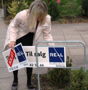 Dorthe Seeberg sætter et SOLGT-skilt op for allerførste gang. Det er fjorten dage efter hun fik salgsopgaven. Foto: Ole Kæhler