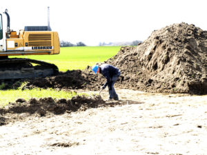 Arkæologerne viser hvordan man graver. Foto: Merete Essenbæk. 